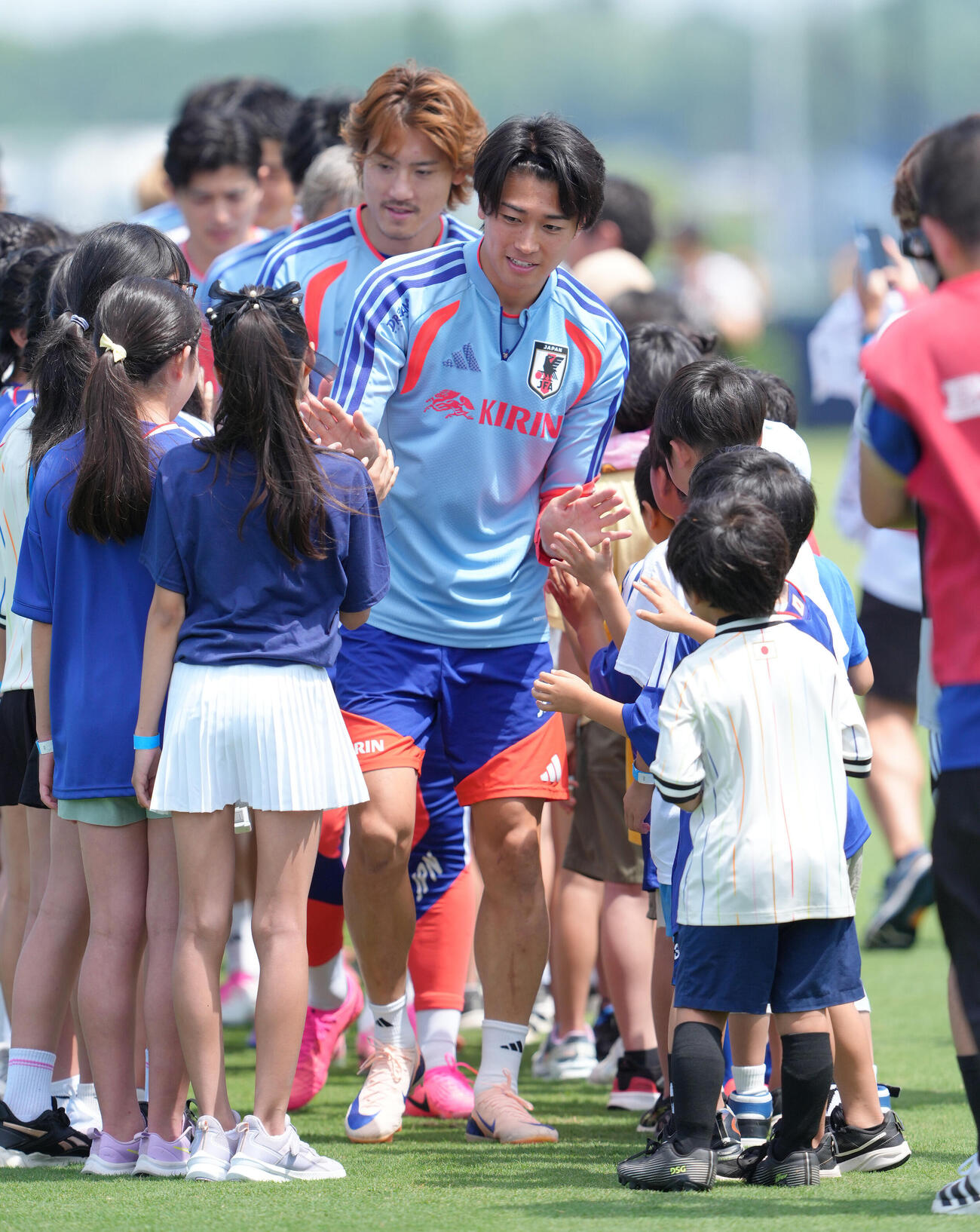 練習前、訪れた現地の子どもたちとタッチを交わす中村敬斗（撮影・足立雅史）