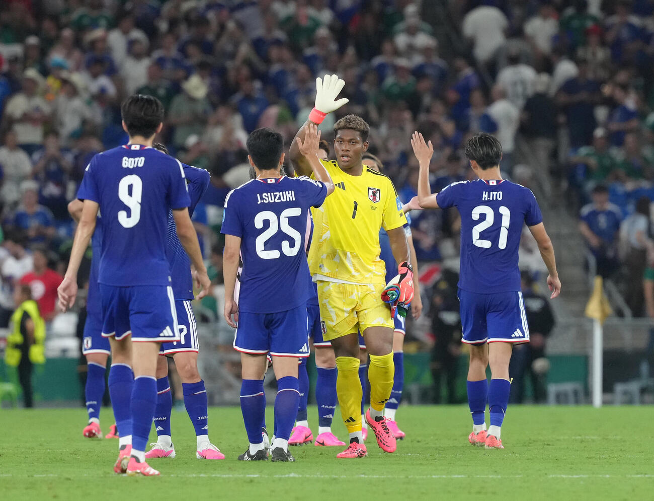日本対チュニジア　快勝し、タッチを交わすGK鈴木彩艶（中央右）ら（撮影・足立雅史）