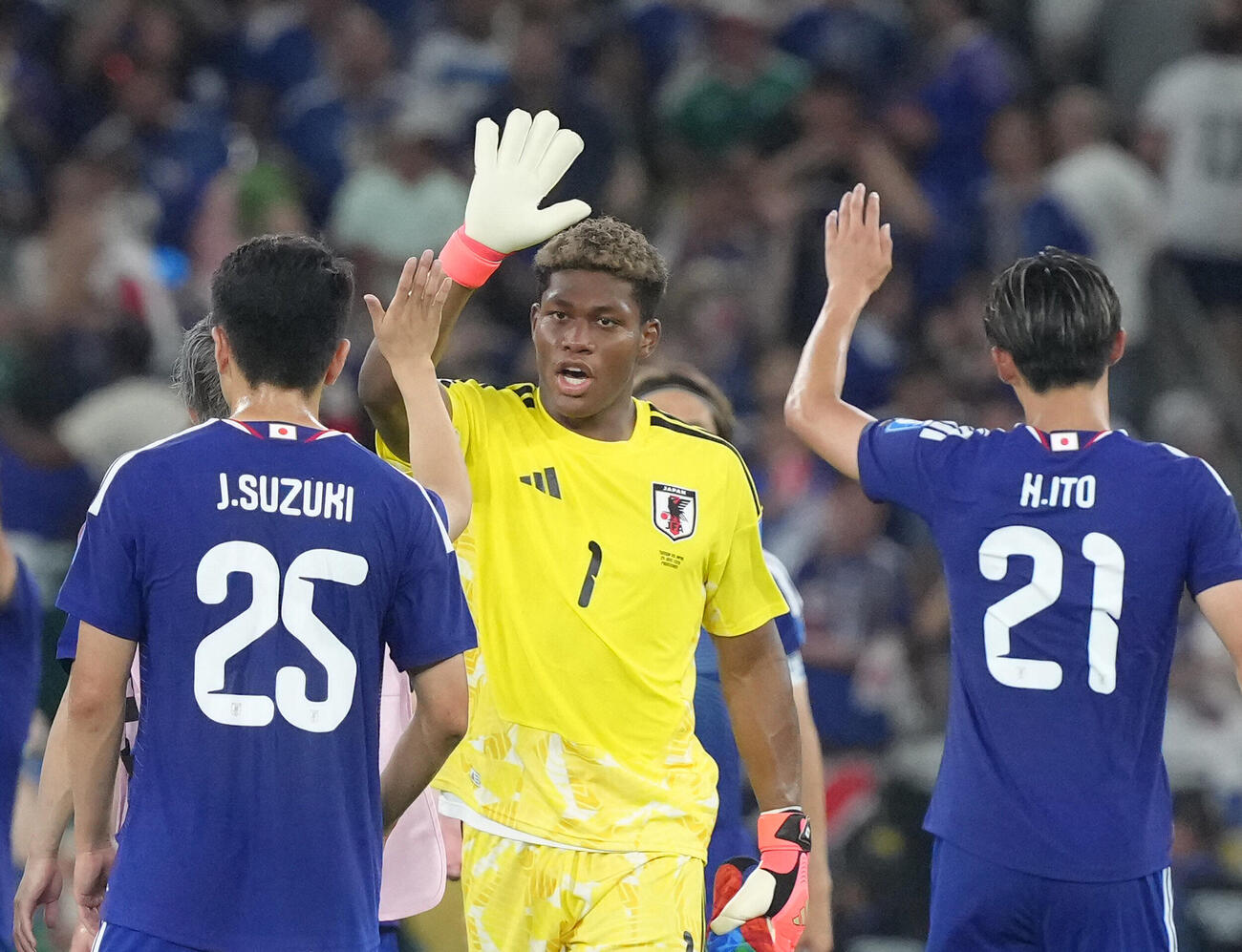 日本対チュニジア　快勝し、タッチを交わすGK鈴木彩艶（中央右）ら（撮影・足立雅史）