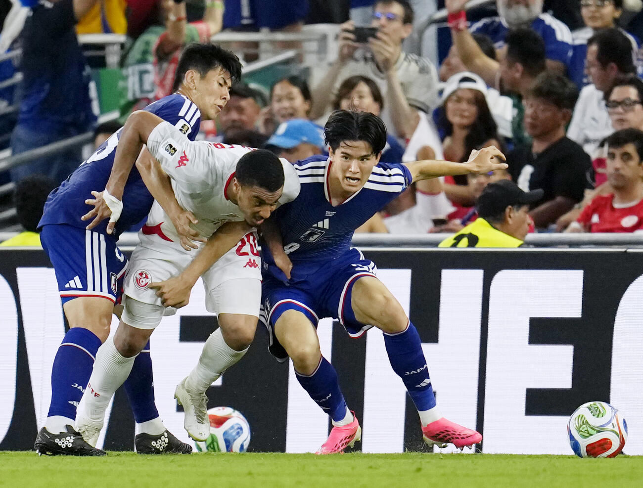 日本対チュニジア　後半、相手選手と競り合う後藤（右）と鈴木淳（左）（共同）