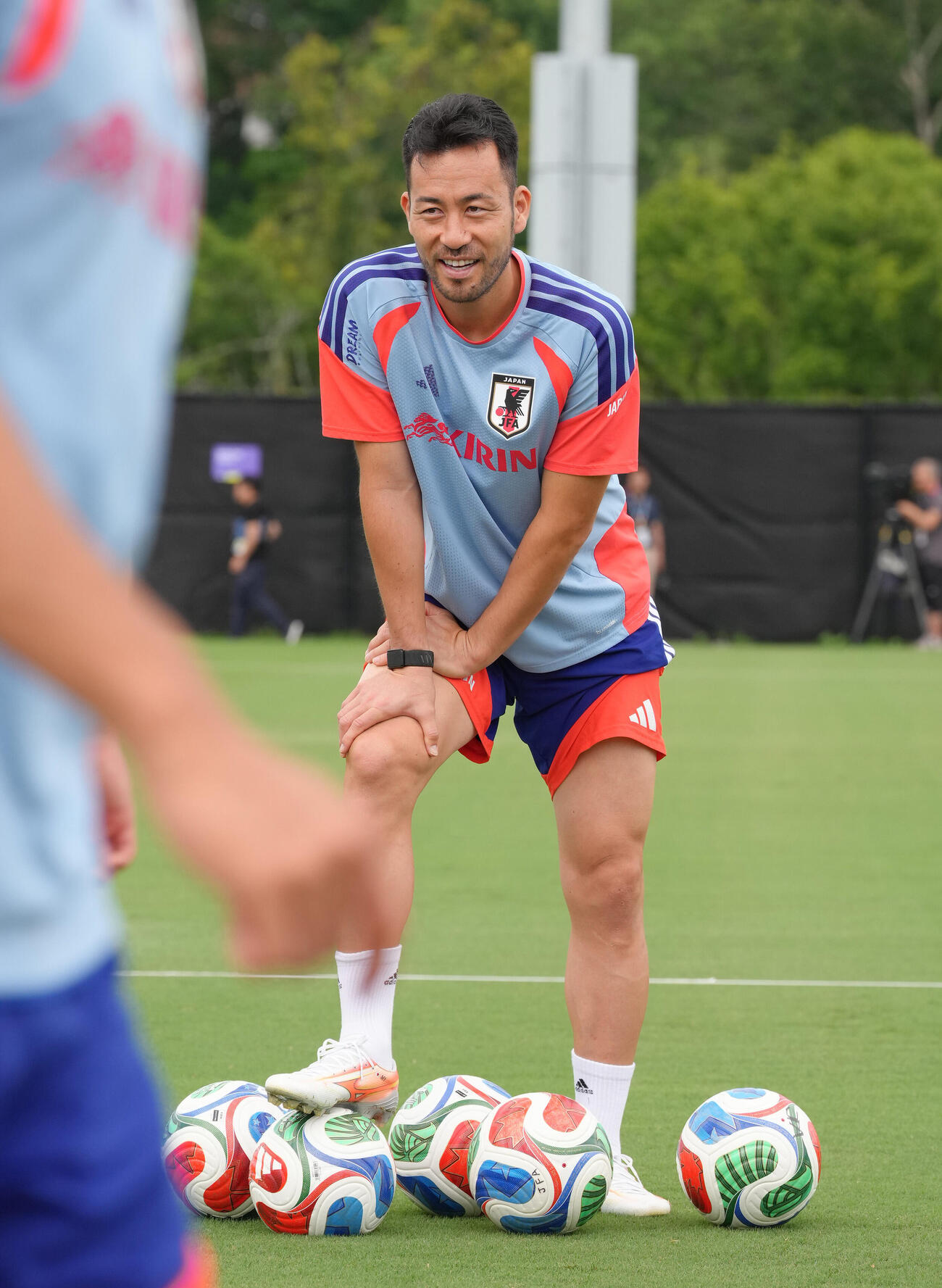 笑顔で練習を見つめる吉田麻也（撮影・足立雅史）