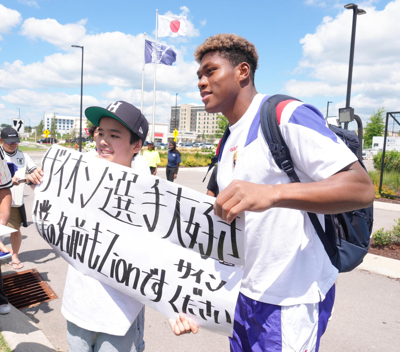 練習後、ファンの「ザイオンくん」（左）と記念撮影するGK鈴木彩艶（撮影・足立雅史）