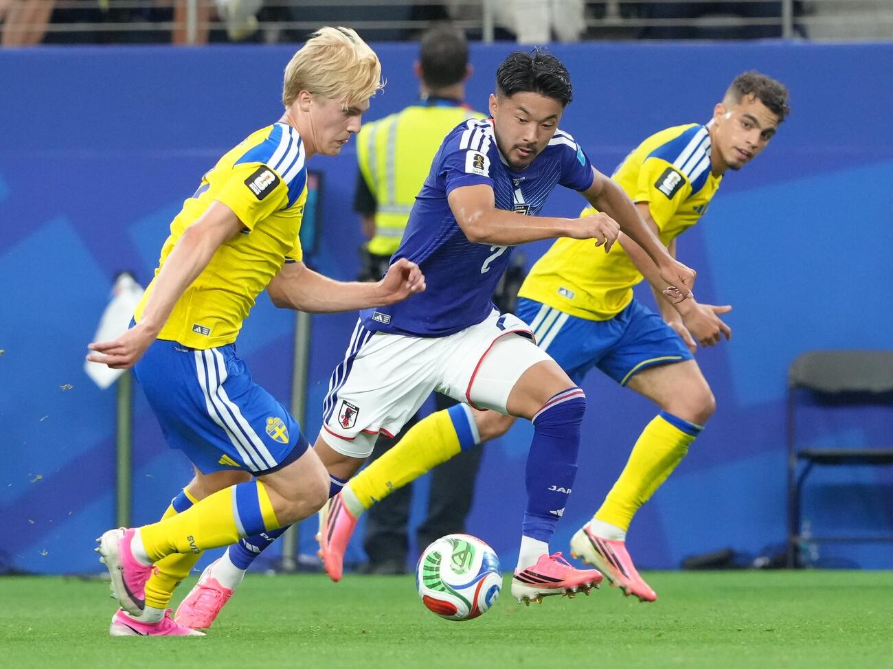 日本対スウェーデン　前半、ディフェンスする菅原由勢（中央）（撮影・足立雅史）