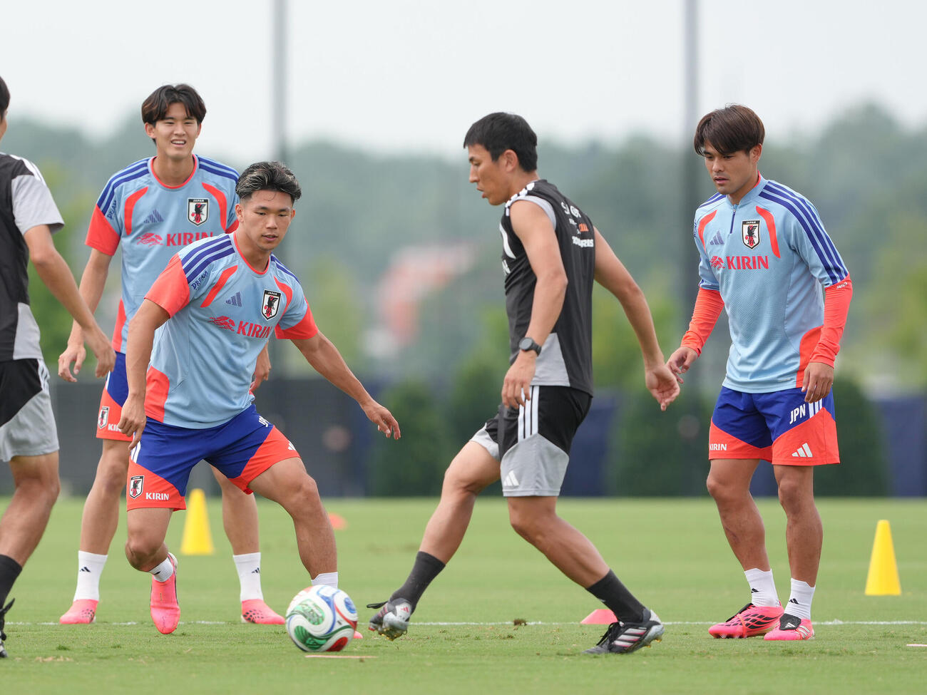ボール回しする、左から後藤啓介、塩貝健人、長谷部誠コーチ、佐野海舟（撮影・足立雅史）