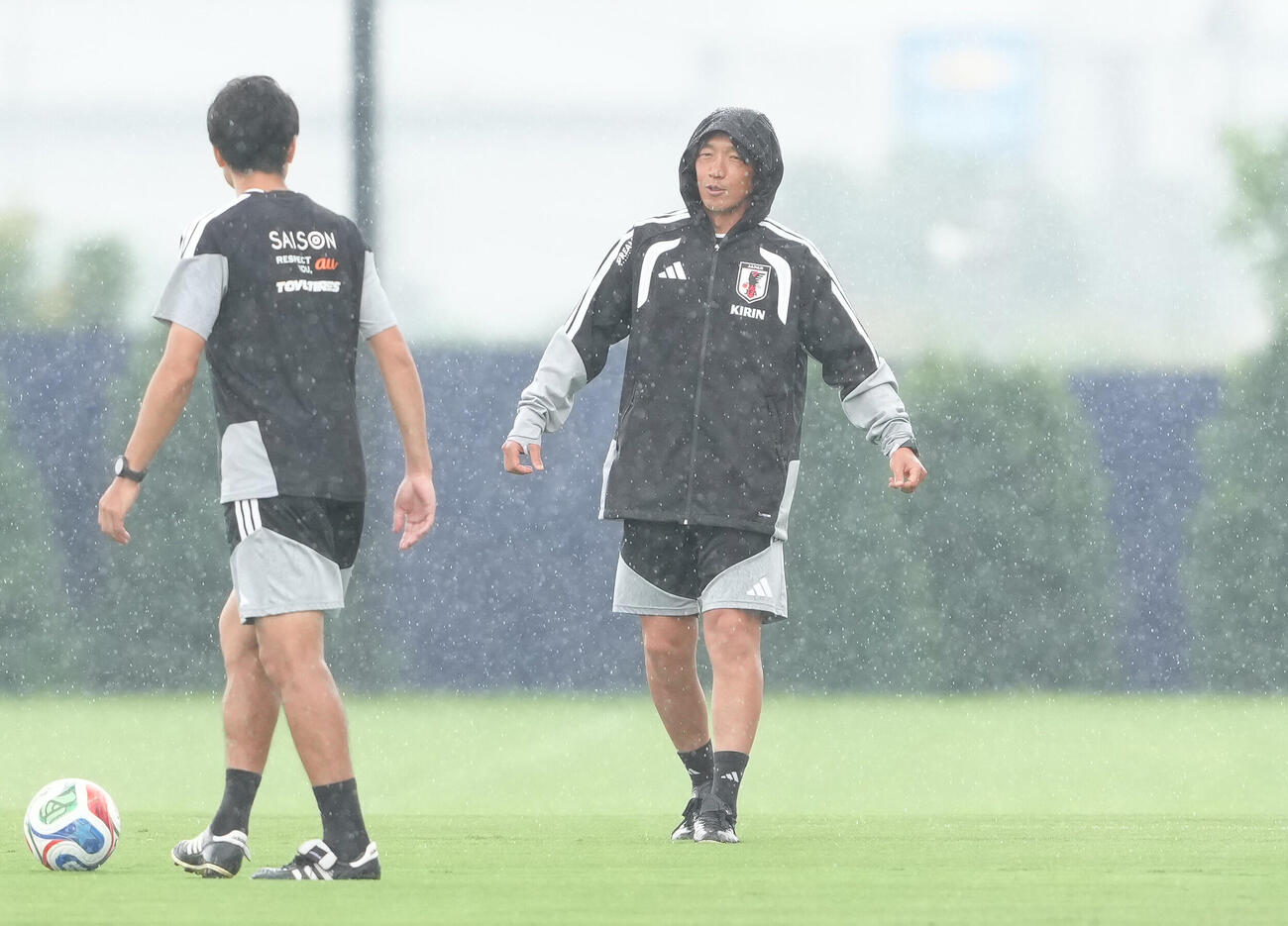 練習前、雨の中、体を動かす中村俊輔コーチ（撮影・足立雅史）