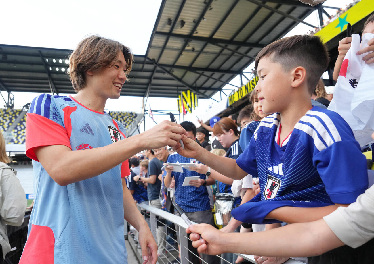 サッカー日本代表W杯北中米大会ベースキャンプ　スタンドのファンのサインに応える板倉滉（撮影・足立雅史）