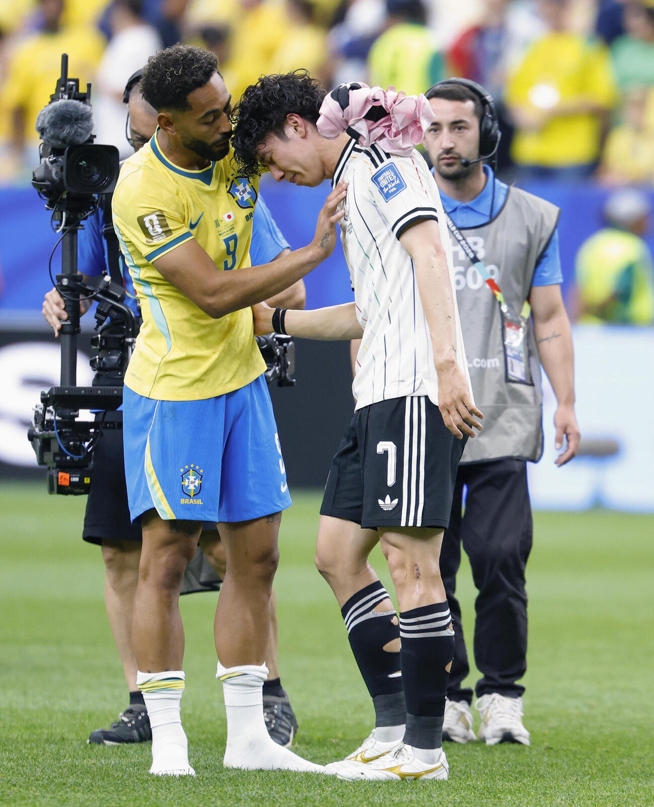 試合を終え、肩を落とす田中をねぎらうブラジルのクニャ（左）（共同）