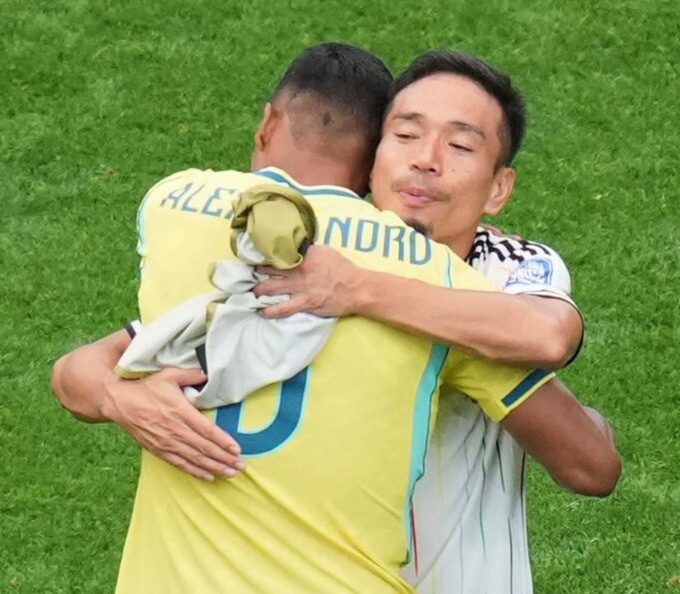 ブラジルのアレックスサンドロと抱き合う長友佑都（AP）