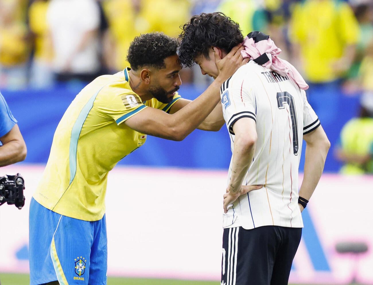 試合を終え、肩を落とす田中をねぎらうブラジルのクニャ（左）（共同）