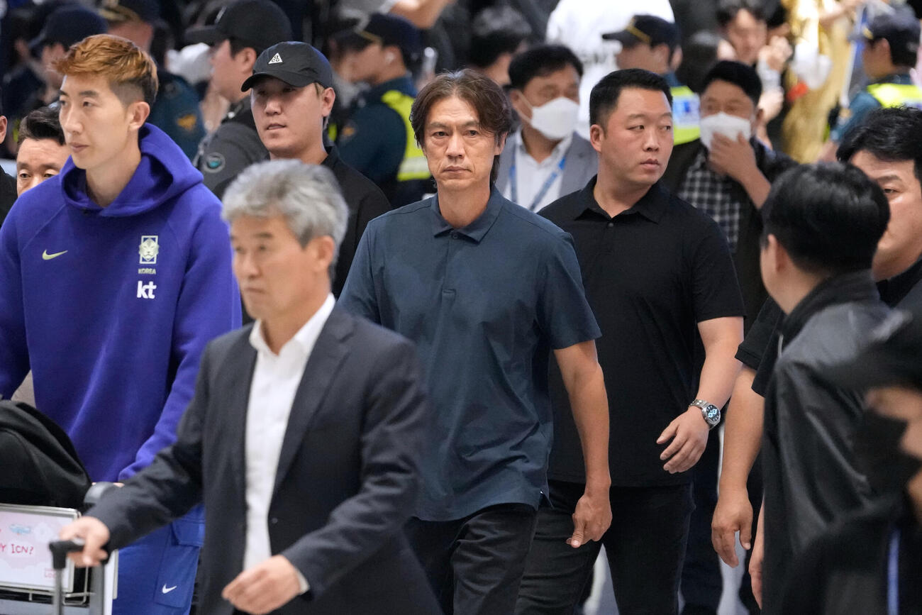帰国した韓国代表と監督を辞任した洪明甫氏（中央、AP）