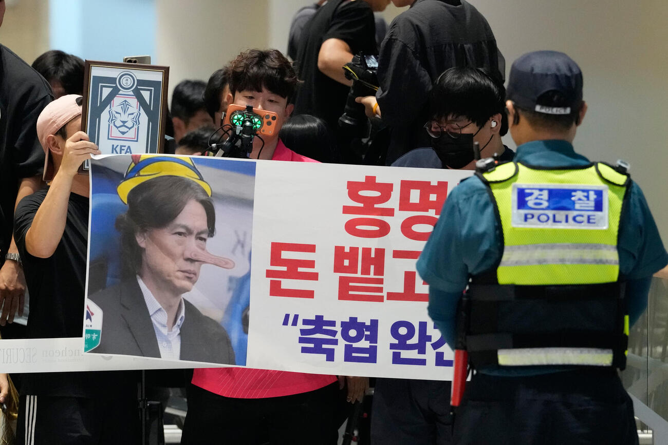 批判する横断幕を掲げる韓国サポーター（AP）