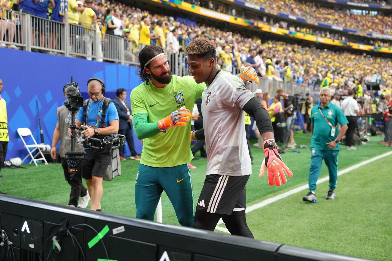日本対ブラジル　試合前練習でブラジルGKアリソン（左）から声をかけられるGK鈴木彩艶（撮影・足立雅史）