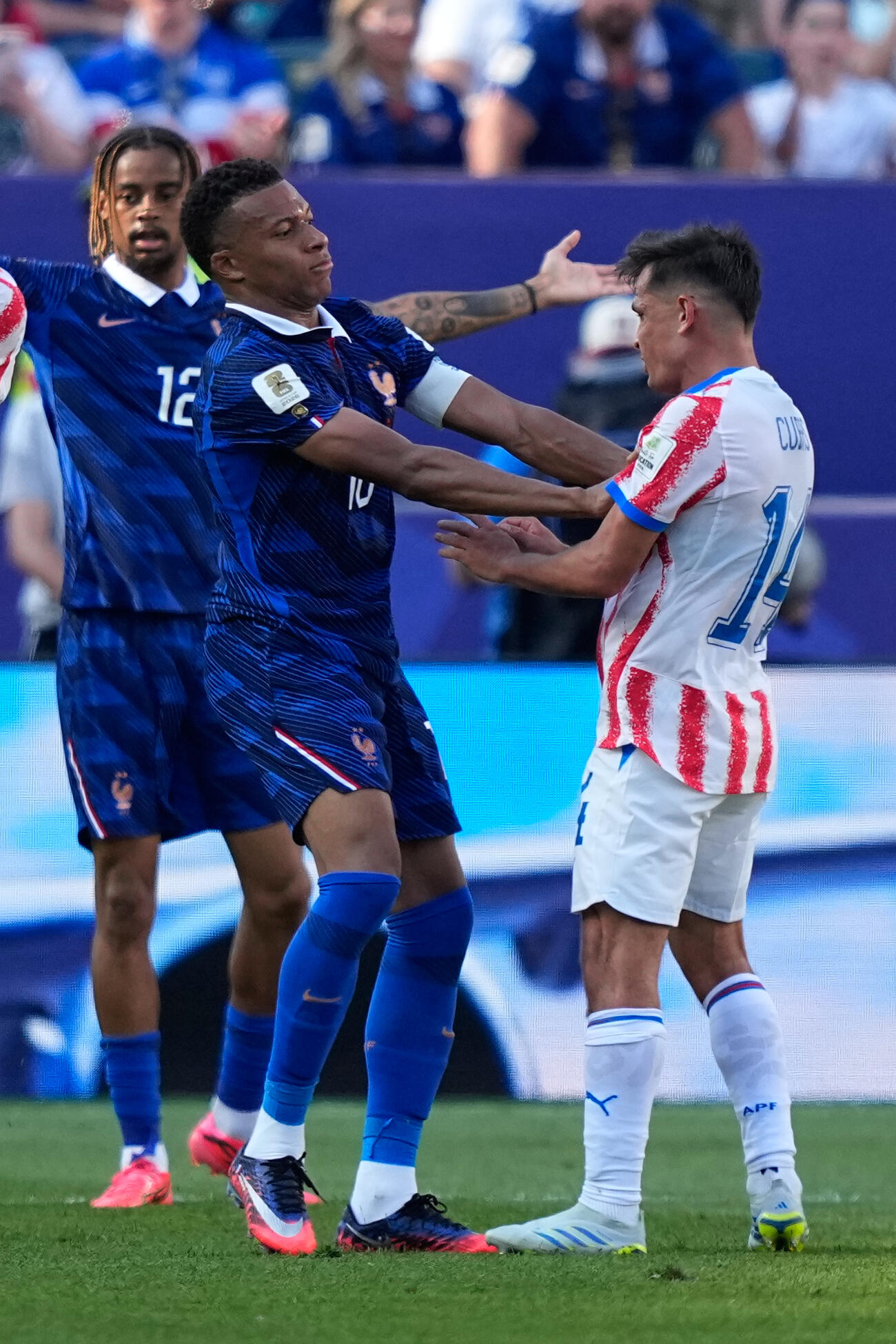 試合中、もみ合うフランスのエムバペ（左）とパラグアイのクバス（AP）　