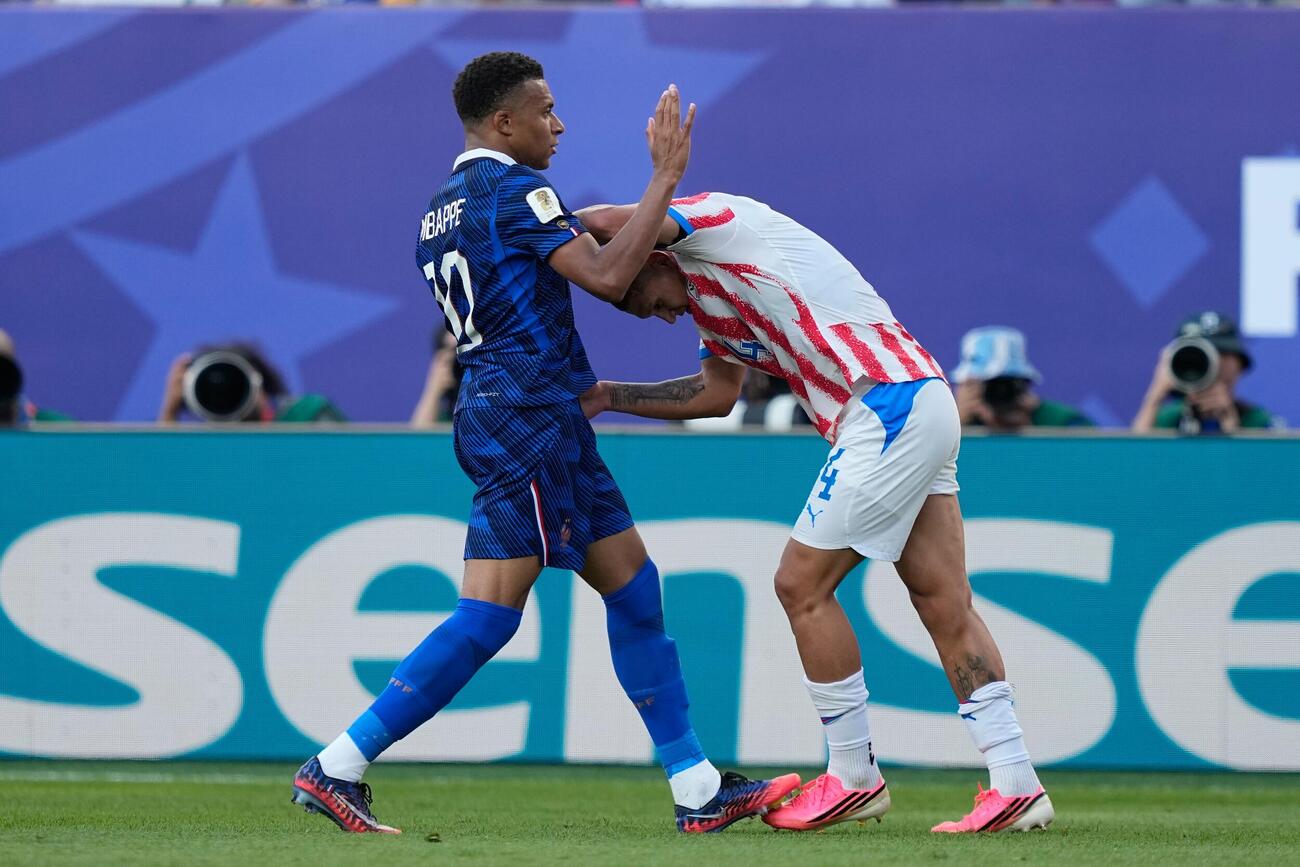 試合中、もみ合うフランスのエムバペ（左）とパラグアイのカセレス（AP）　