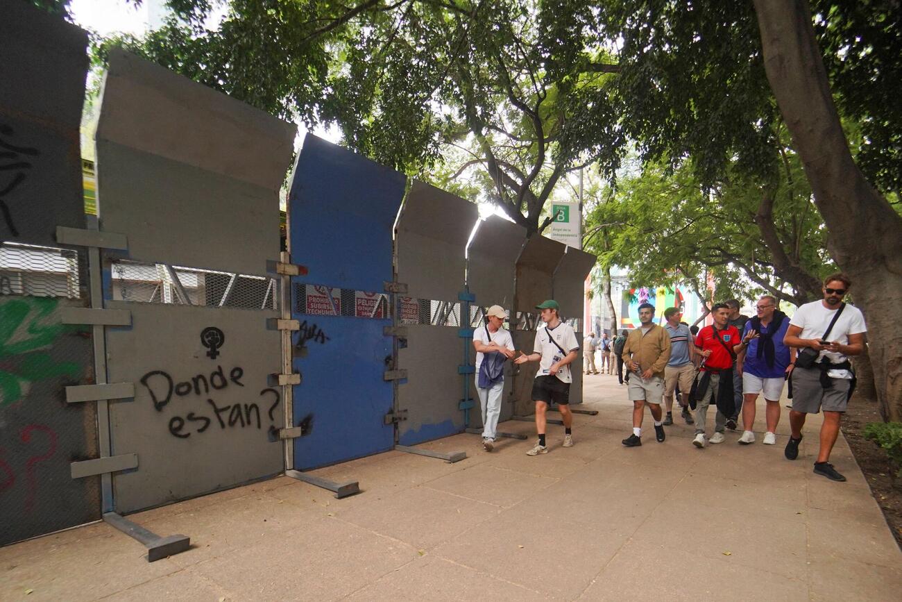 2026年7月4日、メキシコシティで行われるFIFAワールドカップ・決勝トーナメント1回戦のメキシコ対イングランド戦を前に、群衆整理のために地元当局が設置したフェンスの横を歩くイングランドのサポーターたち（ロイター）