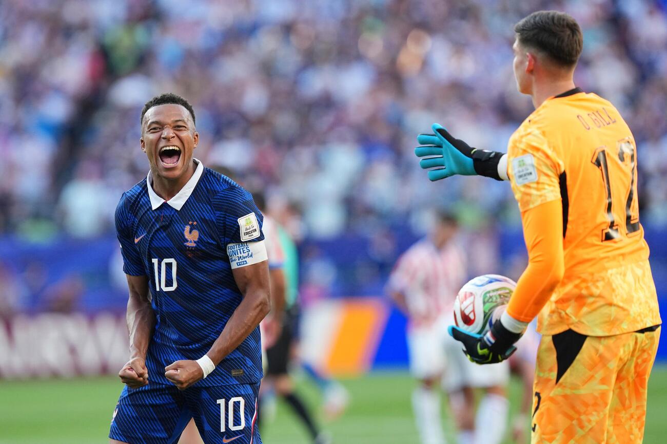 試合後、パラグアイGKヒルが右手を伸ばす前で、力強くガッツポーズするフランスのエムバペ（AP）