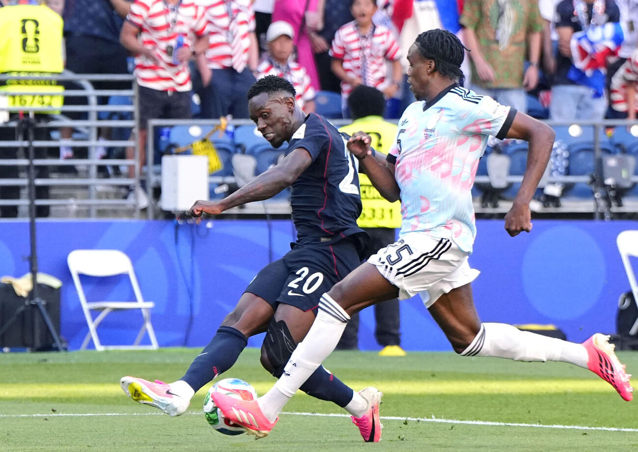 6日、決勝トーナメント2回戦のベルギー戦に出場した米国のバログン（左）（共同）