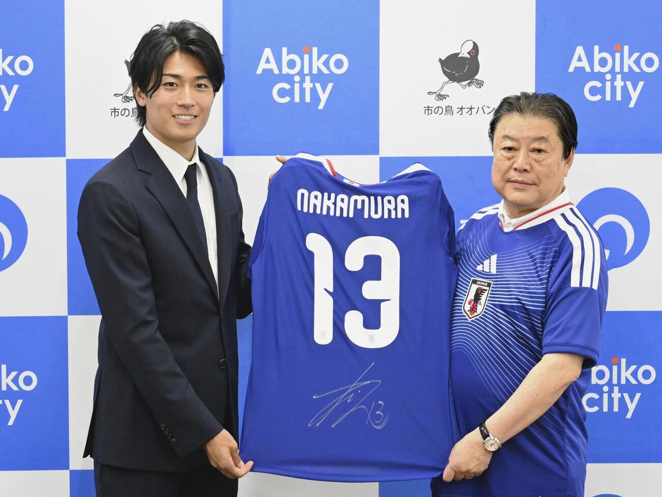 千葉県我孫子市の星野順一郎市長（右）と撮影に応じるサッカー日本代表の中村敬斗＝10日、我孫子市役所（共同）
