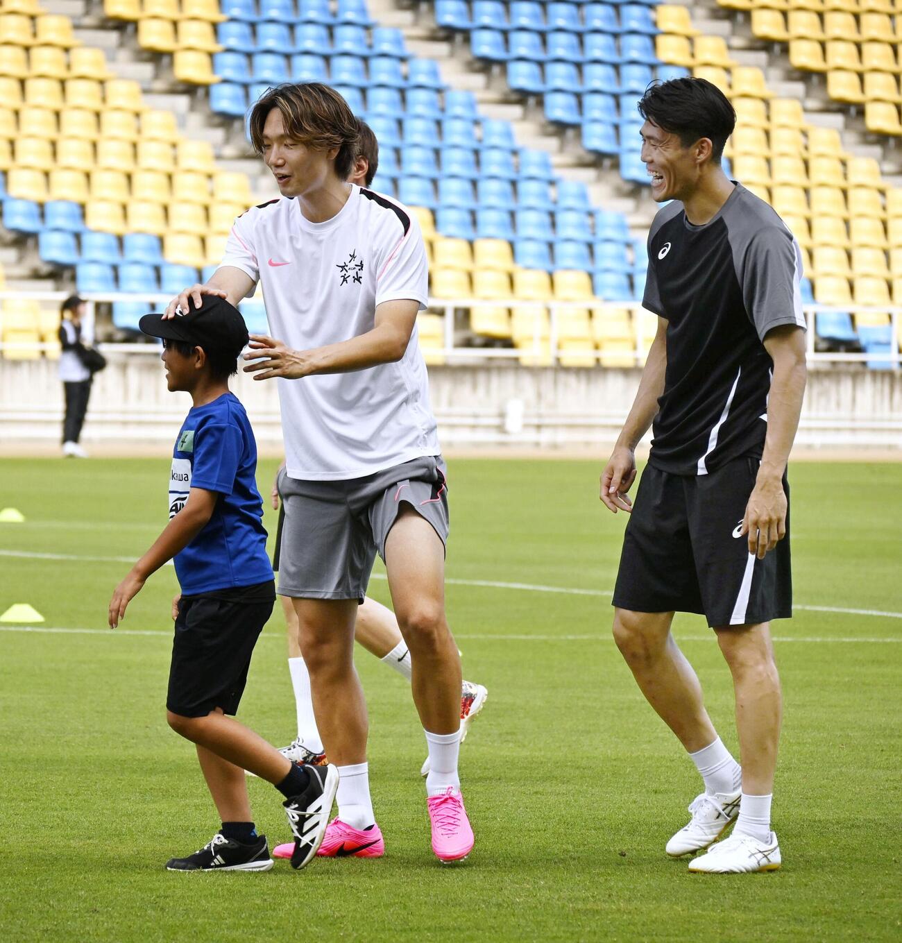 イベントで小学生と交流するサッカー日本代表の板倉滉（左）と冨安健洋＝12日、福岡・ベスト電器スタジアム(共同)