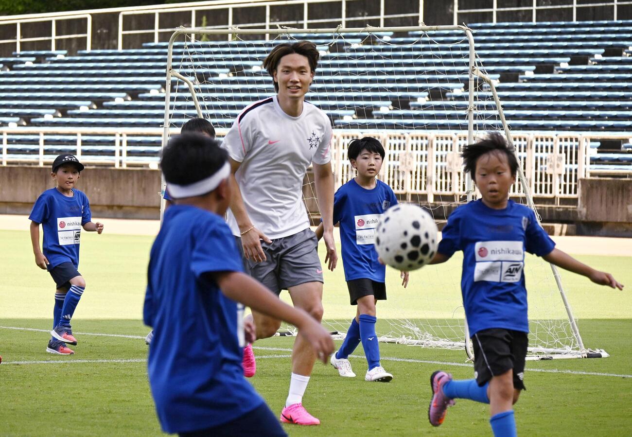 イベントで小学生とプレーするサッカー日本代表の板倉滉＝12日、福岡・ベスト電器スタジアム(共同)