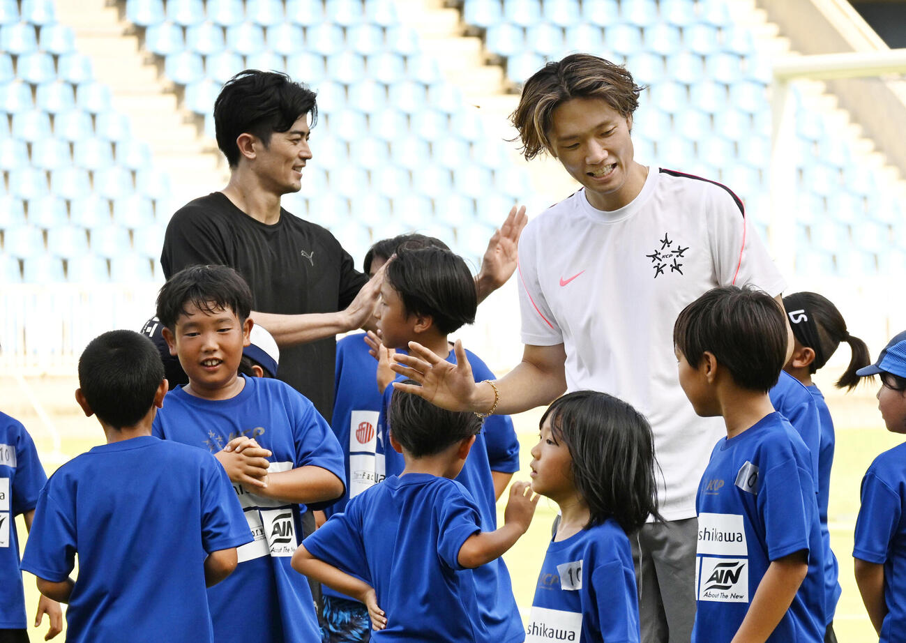 イベントで小学生と交流するサッカー日本代表の板倉滉（右）と谷口彰悟＝12日、福岡・ベスト電器スタジアム(共同)