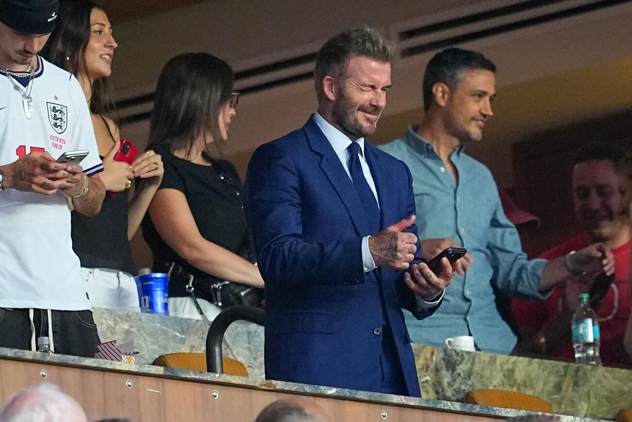 スマホの画面見ながらガッツポーズするデビット・ベッカム氏（AP）