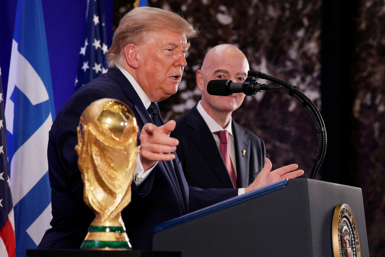 トランプタワーでFIFAのインファンティノ会長を横に、W杯トロフィーを指さしながらスピーチするトランプ大統領（ロイター）