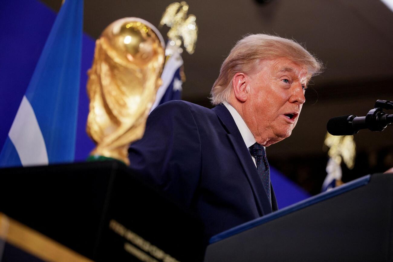 W杯トロフィーの横でスピーチするトランプ大統領（ロイター）