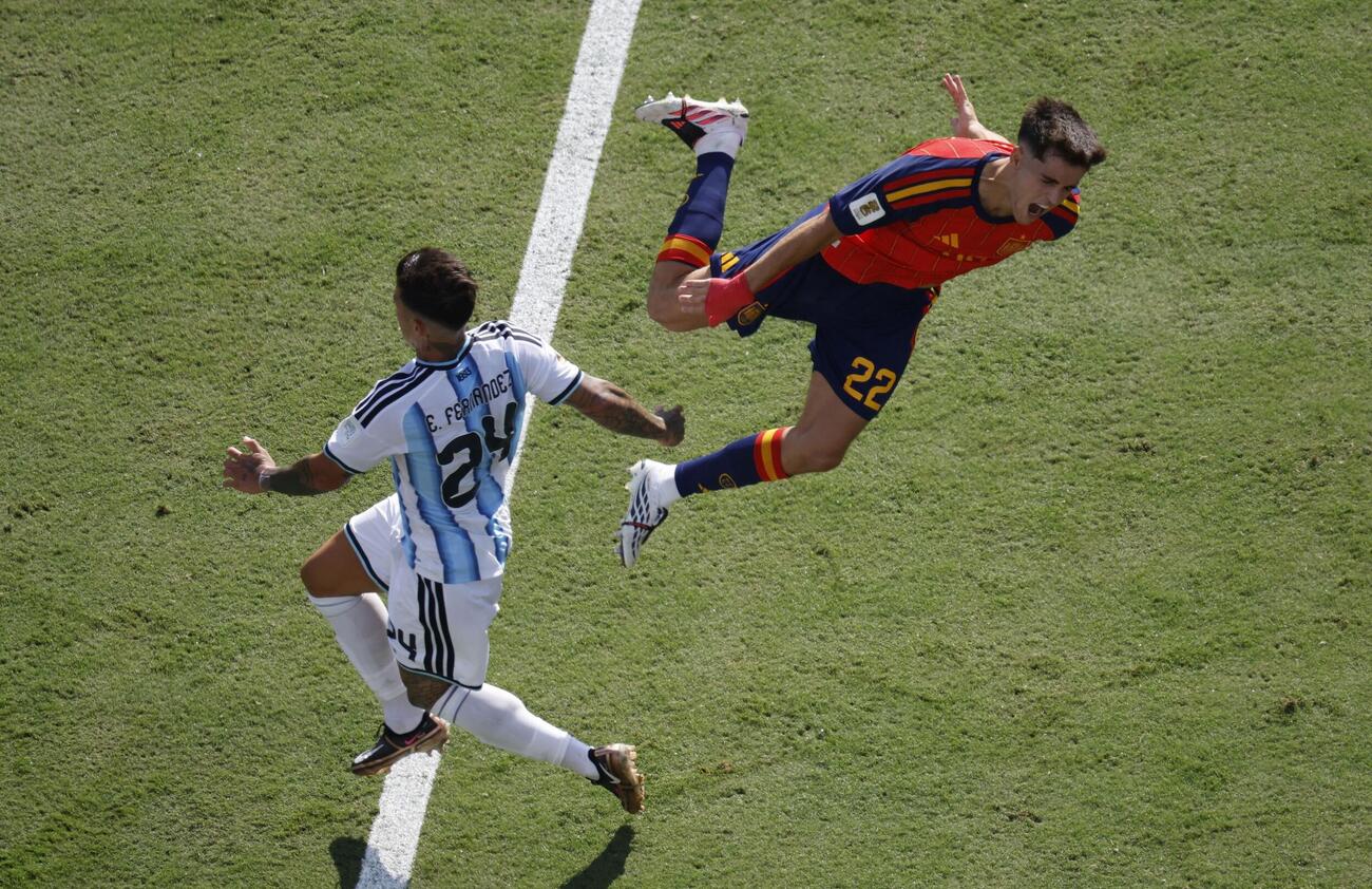 アルゼンチンMFエンソ・フェルナンデス（左）がスペインDFクバルシへ危険なタックル。2枚目のイエローカードを受けて退場となった（ロイター）