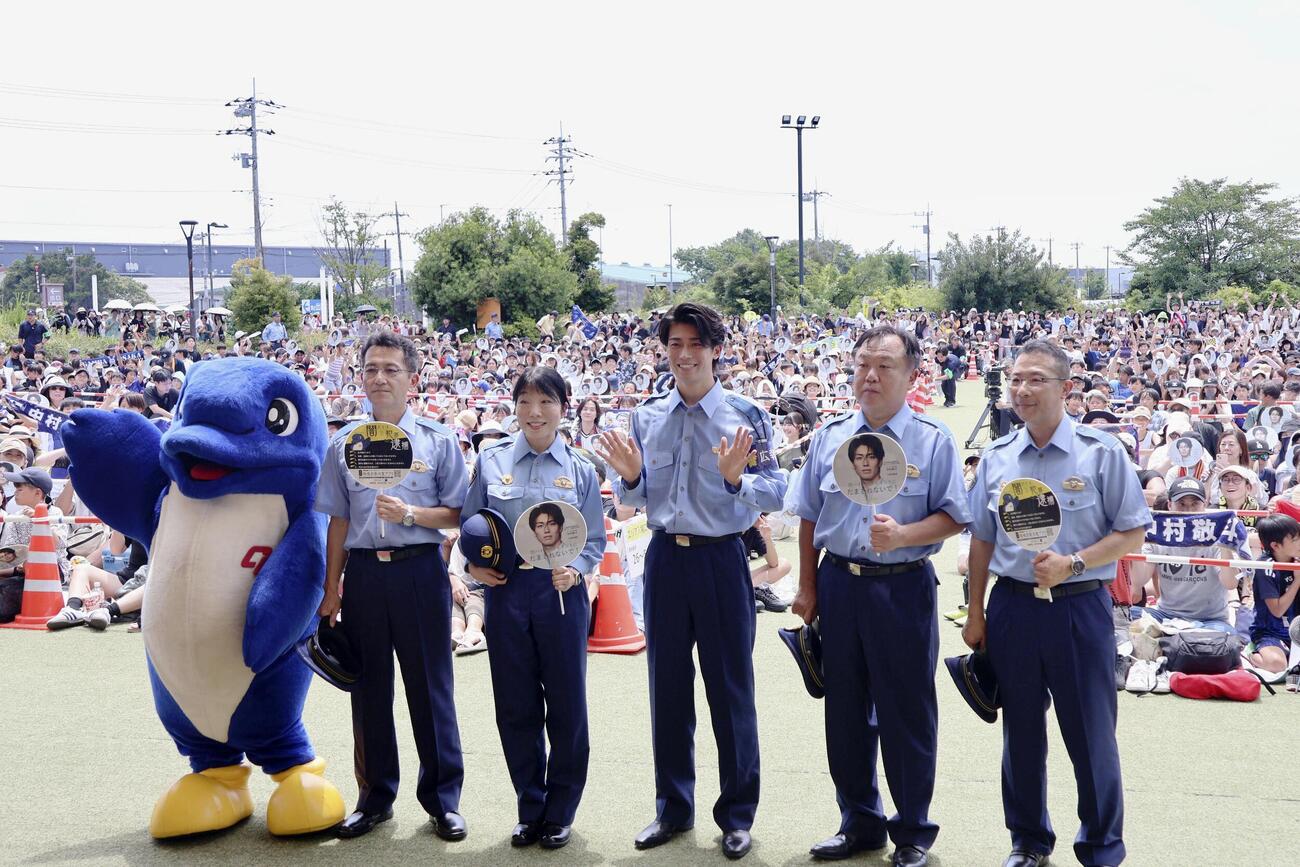 千葉県警の広報官に就任し、会場の観客らと記念写真に納まる中村敬斗（右から3人目）（共同）