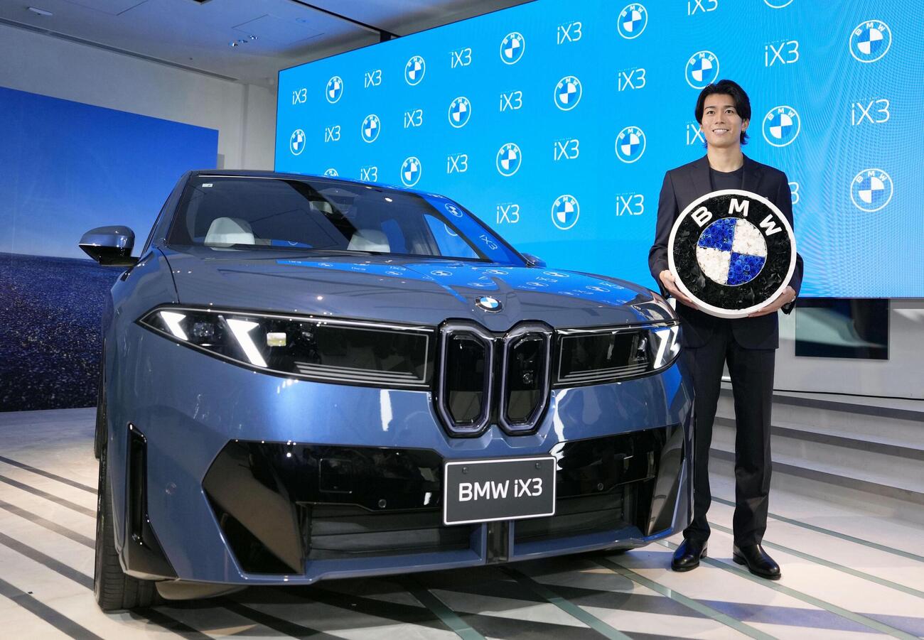 BMWの新型EV「BMW iX3」と写真に納まる中村敬斗（共同）