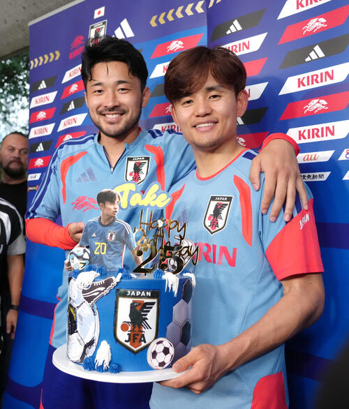この日誕生日の久保建英（右）は菅原由勢からバースデーケーキを受け取り笑顔（撮影・足立雅史）