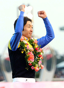 有馬記念の表彰式でファンの声援にガッツポーズで応える武豊騎手（撮影・たえ見朱実）