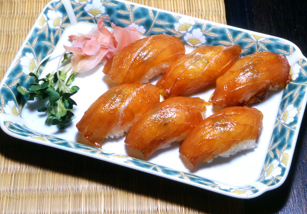 ごく普通のにぎりずしのように見えるが、すしダネはしょう油をくぐらせ、辛味はワサビではなく練りがらし。魚はトビウオやカジキなどの白身魚が多い。八丈島の「島ずし」に似ているのは、サトウキビ栽培のために移住してきた八丈島の人たちが伝えたことから。