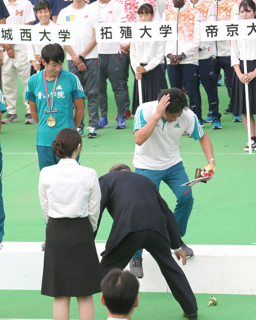 青学大の原晋監督(右)は、表彰式でトロフィーを落とし失笑される(撮影・上山淳一)