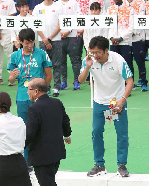 青学大の原晋監督(右)は、表彰式でトロフィーを落とし失笑される(撮影・上山淳一)