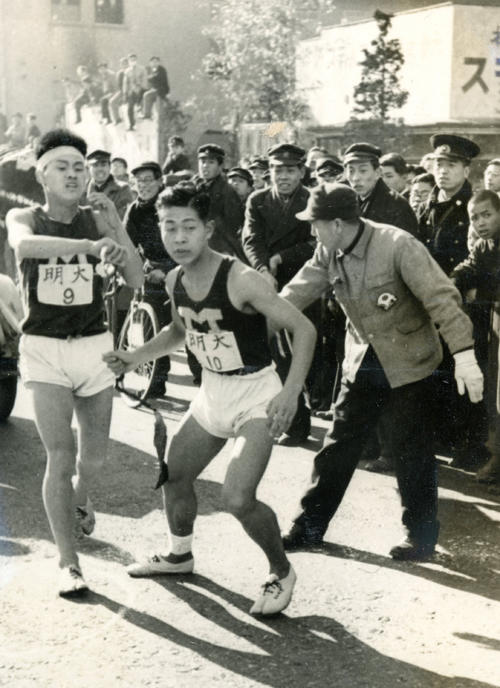 第25回大会　復路10区　鶴見中継所手前で猛然とスパートした明大9区安田正（左）は、早大に27秒差でアンカー木渓博志（右）にタスキリレー（1949年1月6日）
