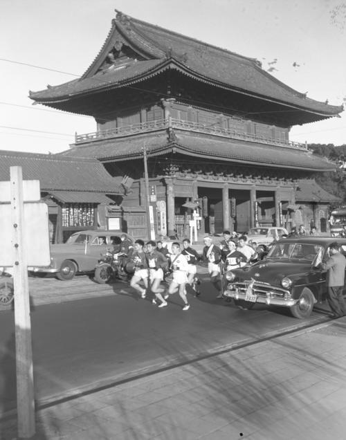 第32回大会　往路1区　増上寺前を先頭グループが一団となって通過（1956年1月2日）