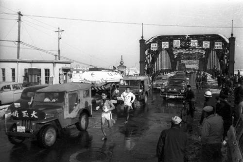 第35回大会　往路1区　六郷橋を渡りトップ争いをする埼玉大・松村敏男（手前＝4年、区間2位）と中大・栗原正視（奥＝3年、区間1位）（1959年1月2日）