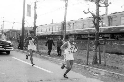 第36回大会　復路10区　大森付近で日大・中島誠（左＝4年）を引き離し独走態勢に入る中大アンカー奥宮和文（右＝2年）（1960年1月3日）