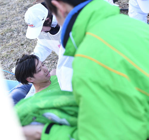 鶴見中継所22位でたすきをつないだ後、倒れ込み運ばれる大東大1区新井（撮影・鈴木みどり）