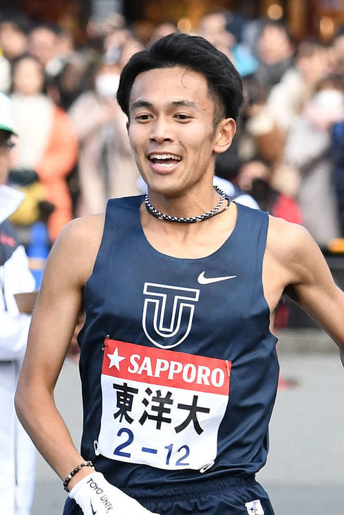小田原中継所に区間新記録の1位で到着し、5区田中龍誠（右）にたすきを渡す東洋大4区相沢晃