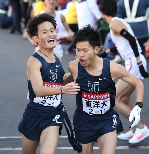 鶴見中継所に1位で到着した東洋大1区西山（左）は2区山本にたすきを渡す（撮影・鈴木みどり）