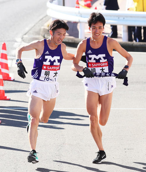 戸塚中継所でたすきリレーする明大8区角出（左）と9区村上（撮影・足立雅史）