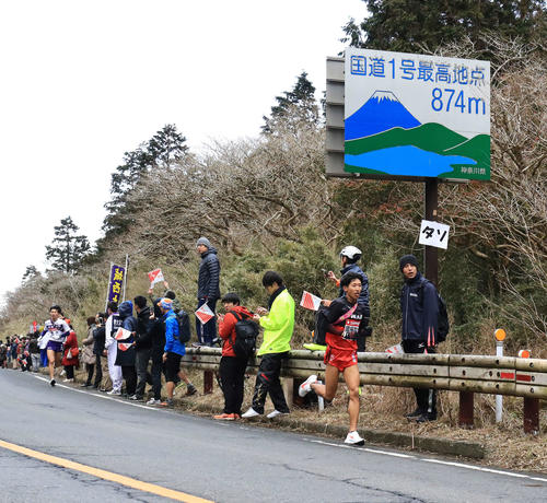 標高874メートルの国道1号最高地点を通過し、ゴールへ向かう国学院大5区浦野。左は順大5区伊東（撮影・江口和貴）
