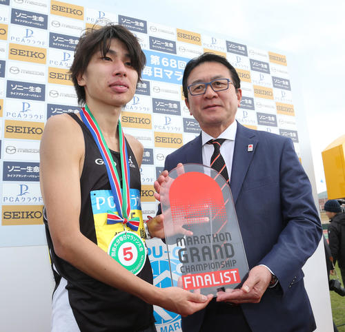総合5位、日本人2位でゴールした橋本崚はマラソングランドチャンピオンシップシリーズの出場権を獲得。瀬古利彦氏(右)からチケットを受ける(撮影・梅根麻紀)