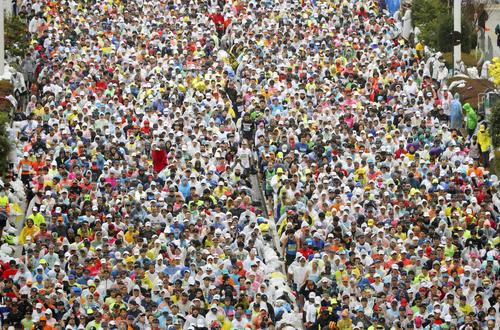 東京マラソンで都庁前を一斉にスタートするランナー（共同）