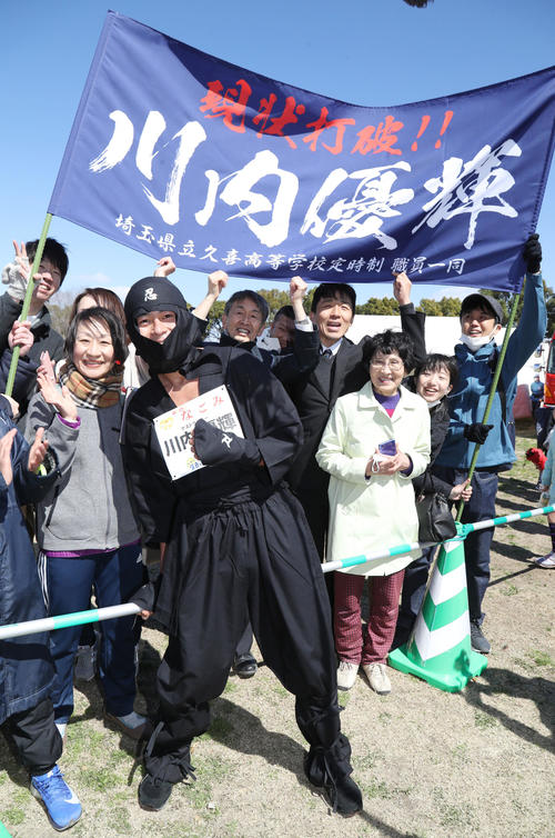 忍者の仮装でゴールし、出迎えた職場の同僚たちと写真におさまる川内（撮影・林敏行）