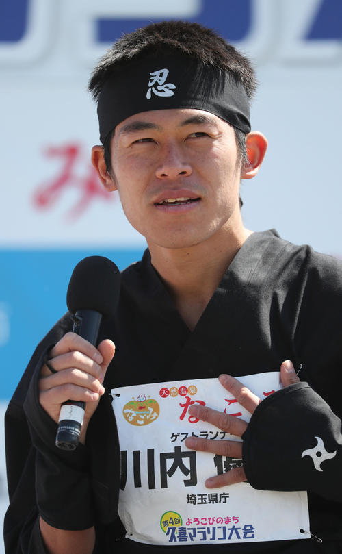 忍者の衣装でトークショーに登場し、埼玉県庁の文字が入ったゼッケンに手を当てて語る川内（撮影・林敏行）