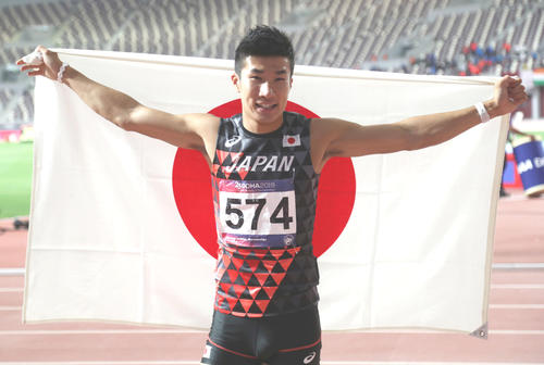 男子100メートルで優勝し、日の丸を掲げる桐生（ロイター）